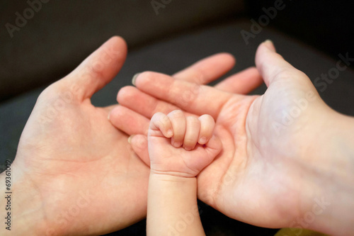 Hands of father, mother and newborn baby. © Vitalinka