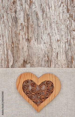 Wooden decorative heart on the linen fabric and old wood