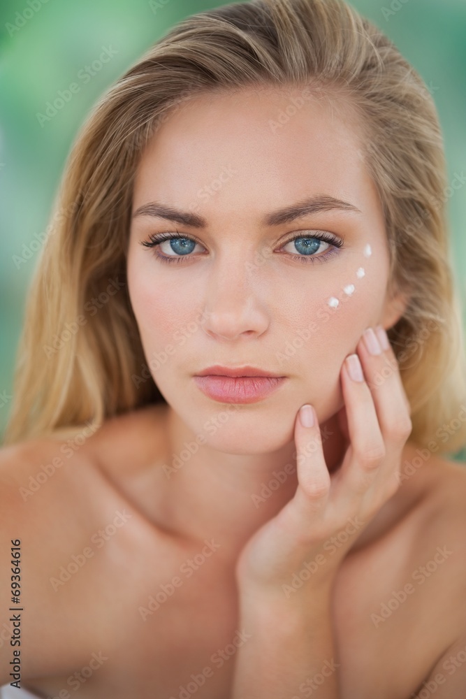 Beautiful natural blonde looking at camera with eye cream on Beautiful natural blonde looking at camera with eye cream on