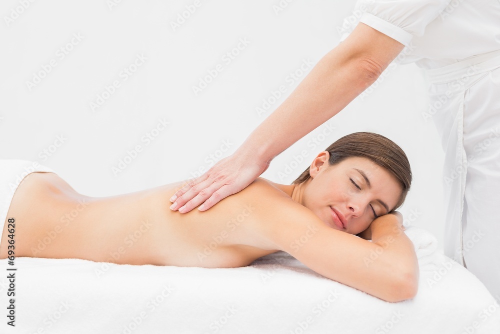 Attractive woman receiving back massage at spa center Attractive woman receiving back massage at spa center