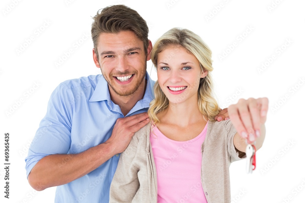 Attractive young couple showing new house key Attractive young couple showing new house key