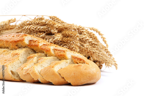 Bread and wheat ears on white background.