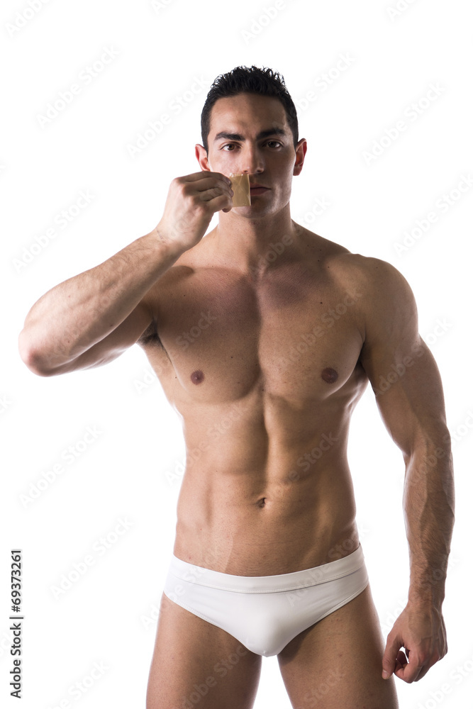 Muscular man removing tape from mouth Muscular man removing tape from mouth