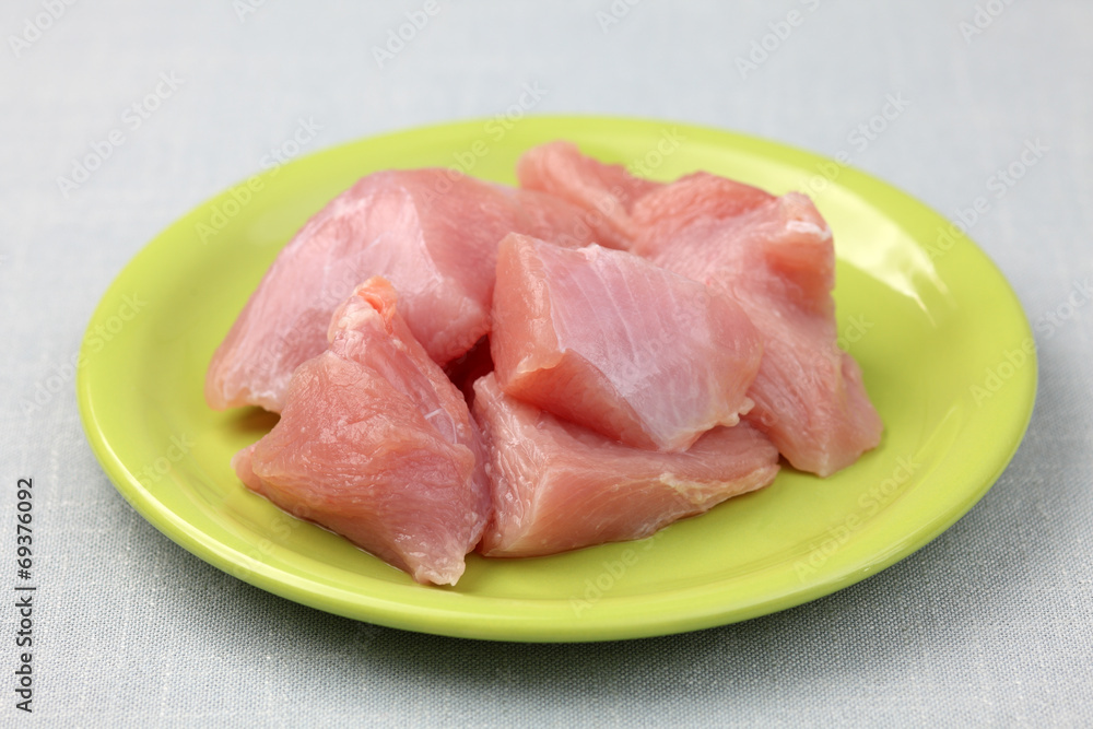 Raw turkey fillet on a green plate Raw turkey fillet on a green plate