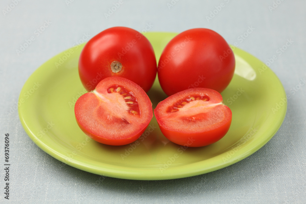 Red fresh tomatoes on a green plate Red fresh tomatoes on a green plate