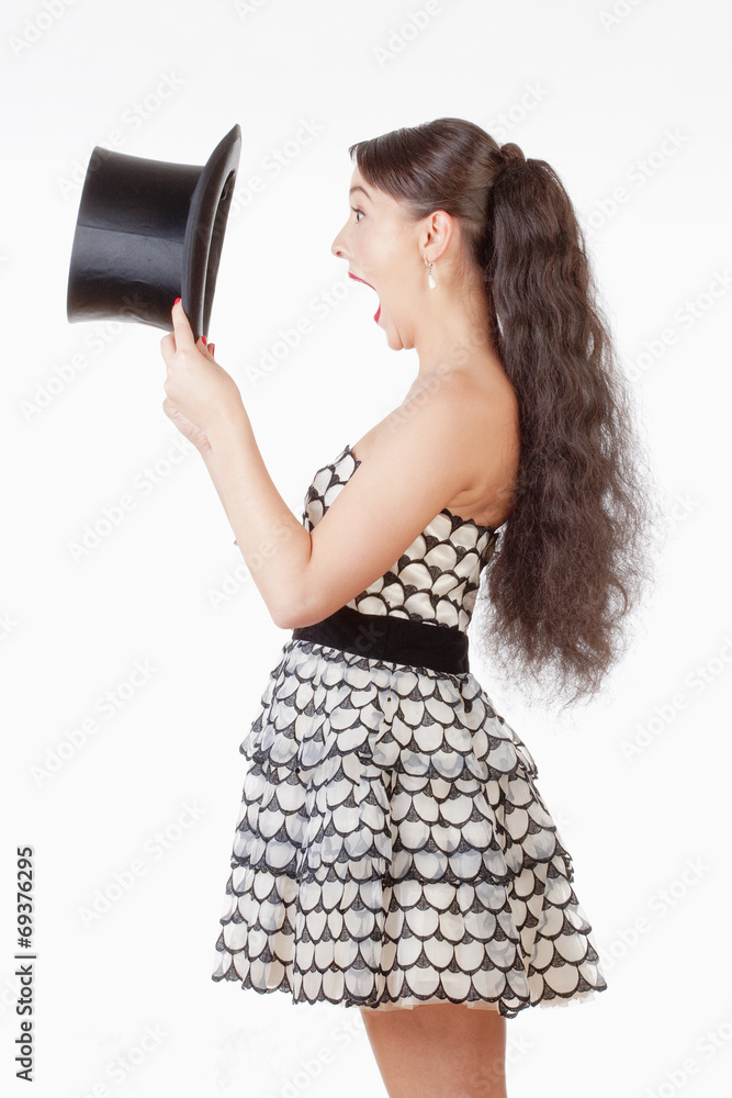 Young Woman with Open Mouth Looking inside Black Hat Young Woman with Open Mouth Looking inside Black Hat