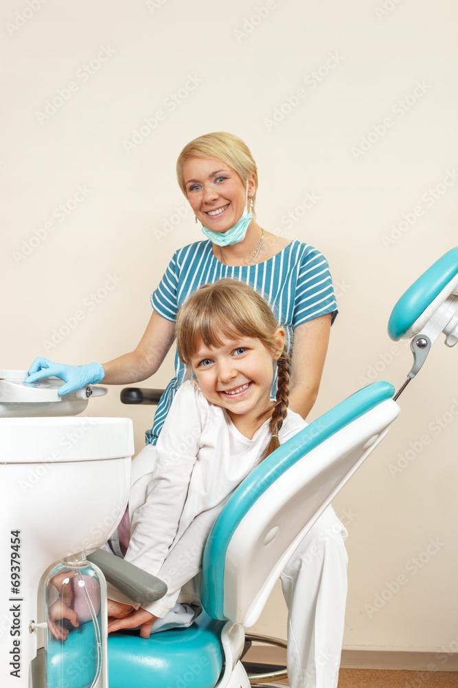 Happy little girl at the dentist. Selective focus on little girl Happy little girl at the dentist. Selective focus on little girl