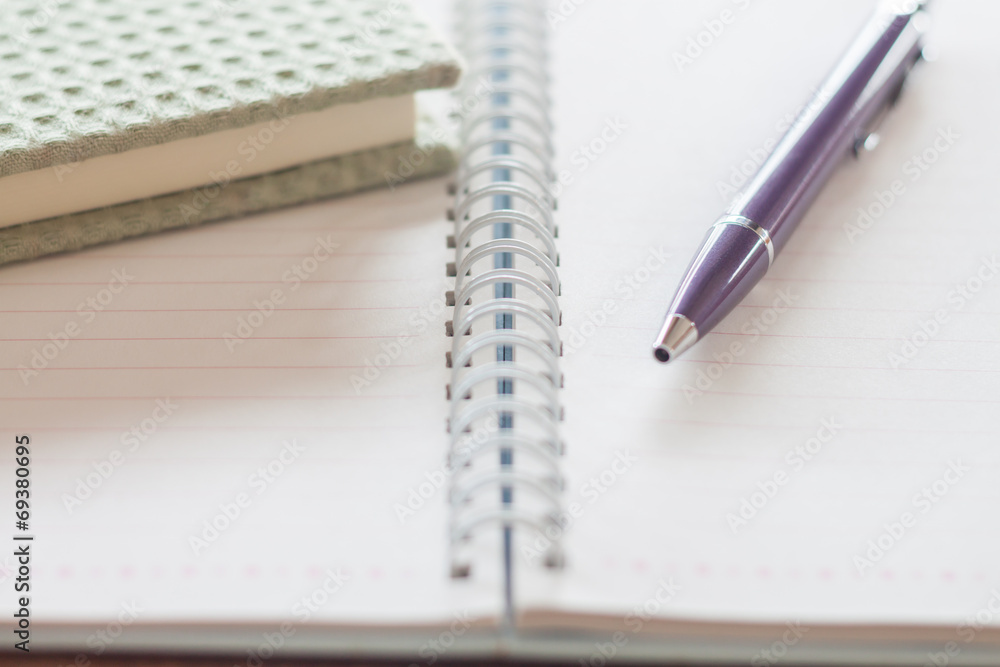 Pen and green notebook on spiral notebook Pen and green notebook on spiral notebook