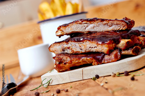 Barbecue ribs on vintage wooden table with french fries photo