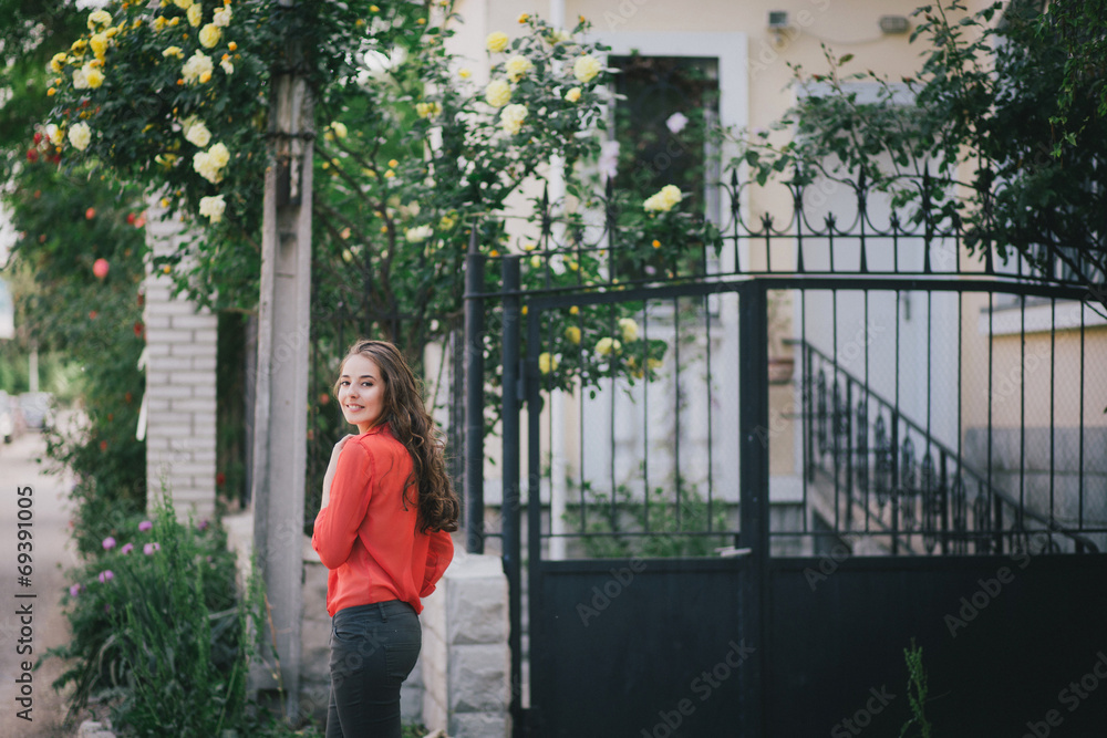 Beautiful girl in a red shirt posing on a street