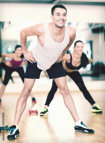 Fototapeta Naklejka Na Ścianę i Meble -  smiling male trainer working out in the gym