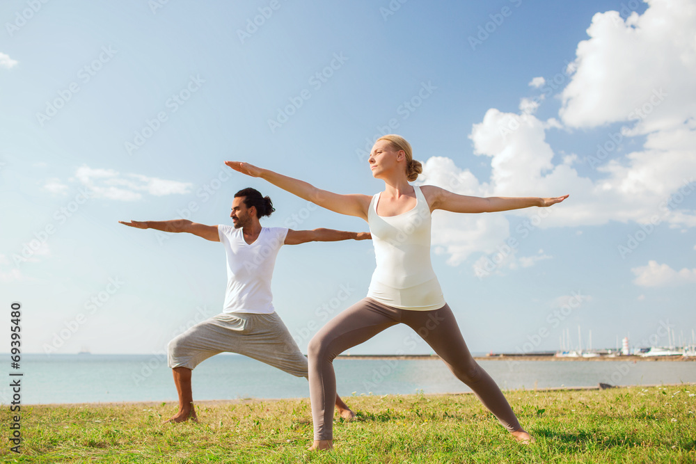 smiling couple making yoga exercises outdoors smiling couple making yoga exercises outdoors