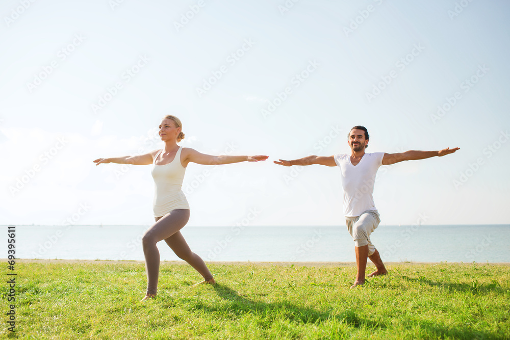 smiling couple making yoga exercises outdoors smiling couple making yoga exercises outdoors