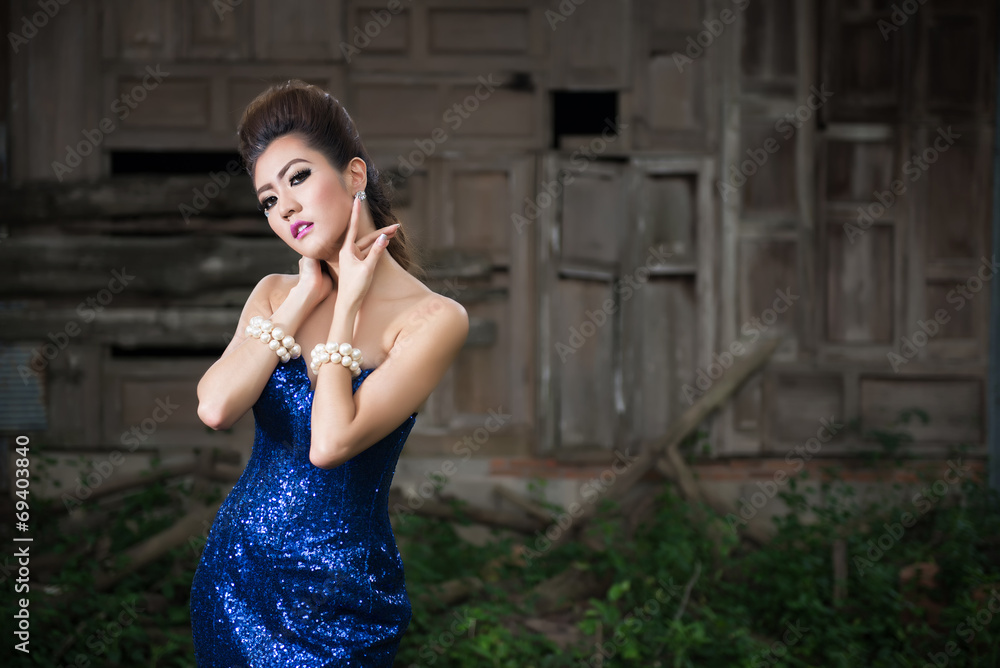 Obraz premium Beautiful lady in luxury blue dress with pearl