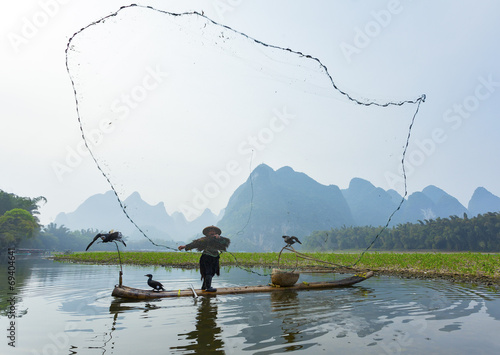 Canvas-taulu Cormorant, fish man and Li River scenery sight
