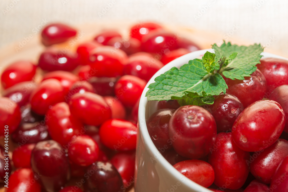 cornel berries in a white cup on a wooden board cornel berries in a white cup on a wooden board