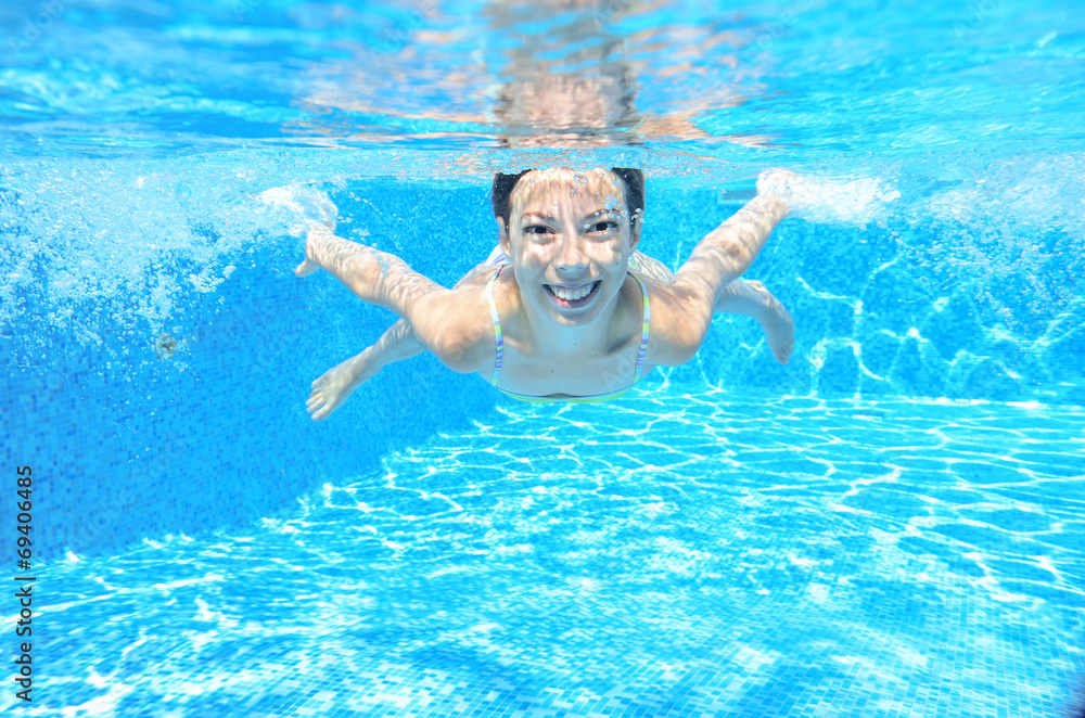 Happy active child swims underwater in pool and have fun