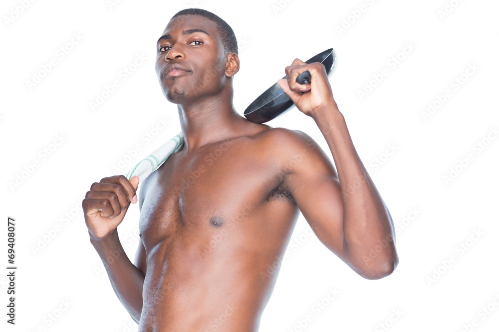 Fototapeta premium Portrait of a fit shirtless man holding frying pan