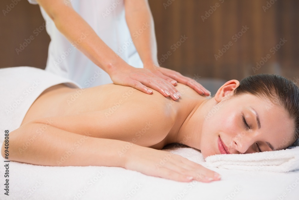 Attractive woman receiving back massage at spa center Attractive woman receiving back massage at spa center