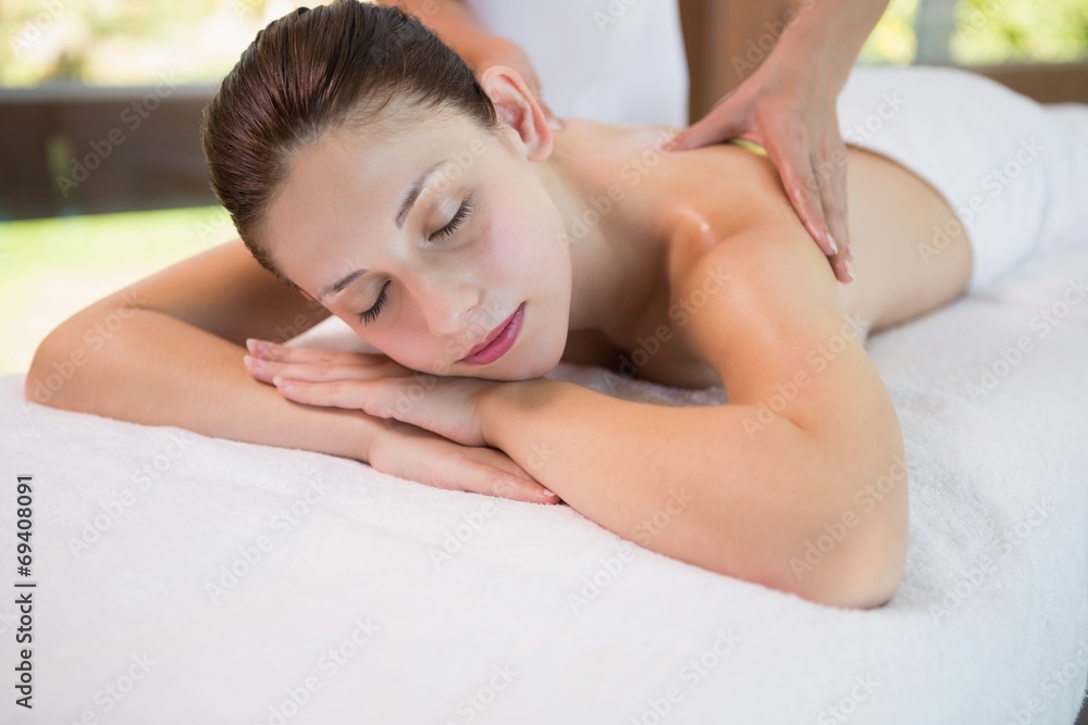 Attractive woman receiving back massage at spa center Attractive woman receiving back massage at spa center