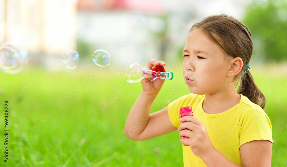 Little girl is blowing a soap bubbles Little girl is blowing a soap bubbles