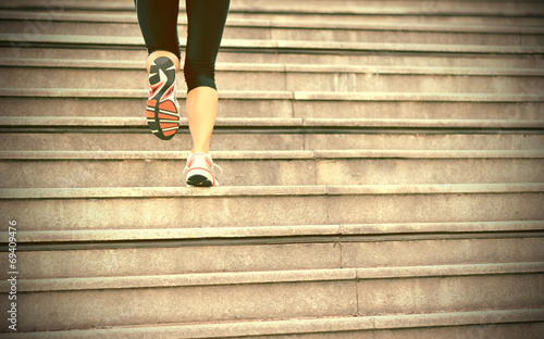 sports woman legs running up on stone stairs 
