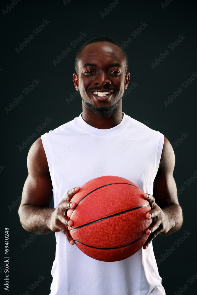 Smiling african american basketball player over black background
