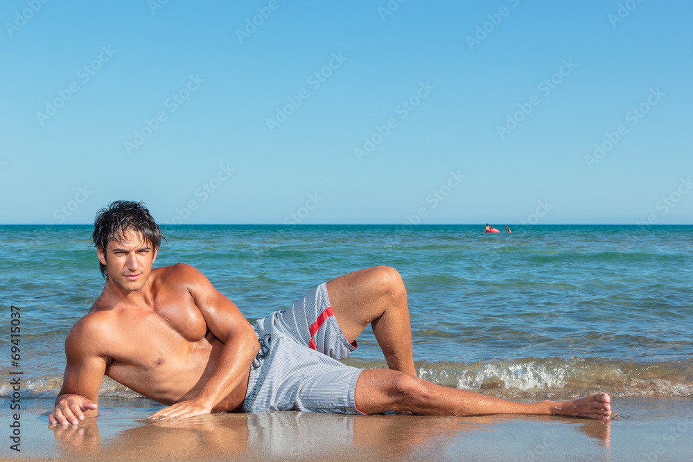 Portrait of a handsome young muscular man in swimwear