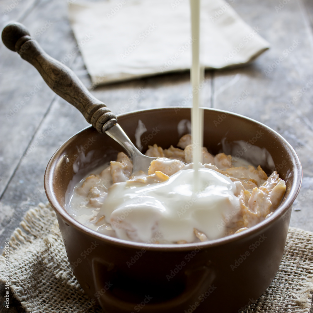 Bowl of cornflakes on wooden table. Bowl of cornflakes on wooden table.