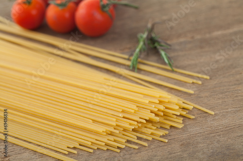 spaghetti with tomatoes basil on wood background