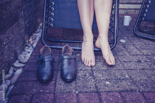 Fotografija Young woman with bare feet relaxing in garden