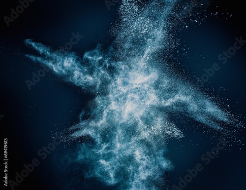 Blue powder exploding isolated on black