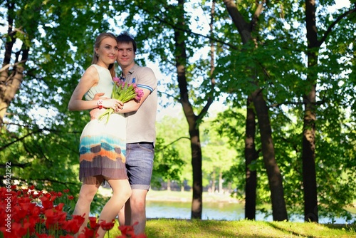 Portrait of a young in love couple near a field of tulips