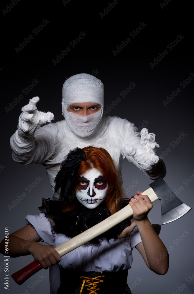 Halloween concept with mummy and woman with axe Halloween concept with mummy and woman with axe