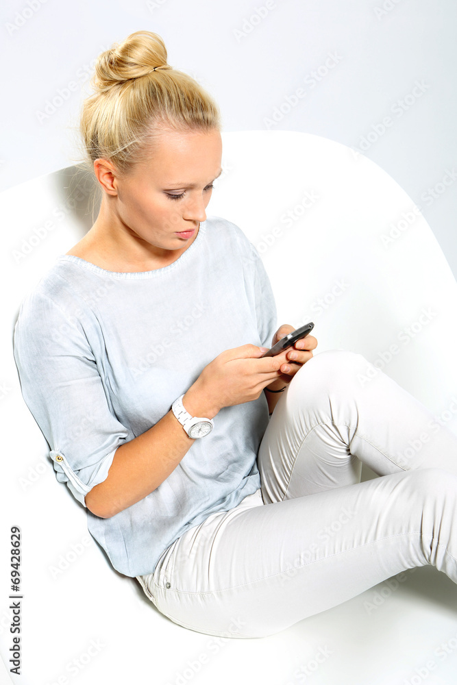 Kobieta z telefonem czyta wiadomość - obrazy, fototapety, plakaty 