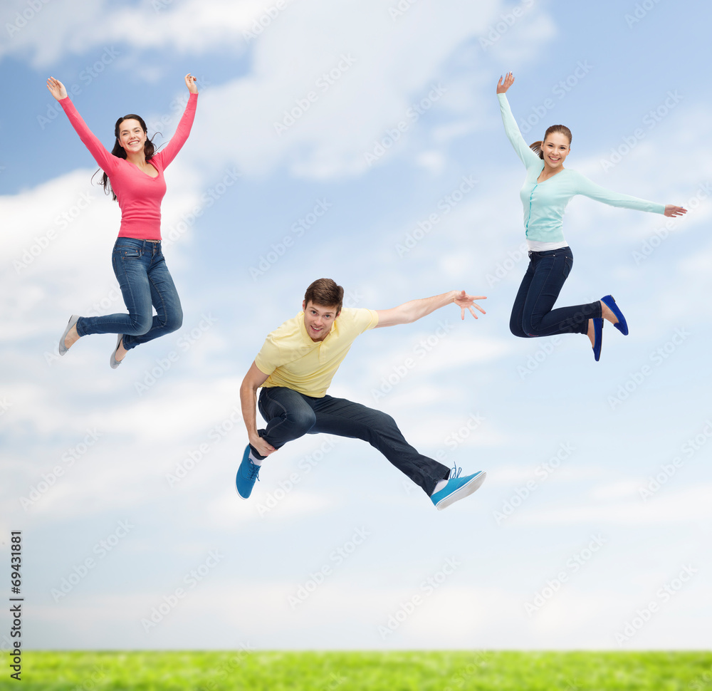 group of smiling teenagers jumping in air group of smiling teenagers jumping in air