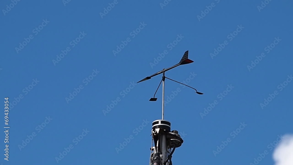 Marine weather wind vane on top of a sail boat mast Marine weather wind vane on top of a sail boat mast