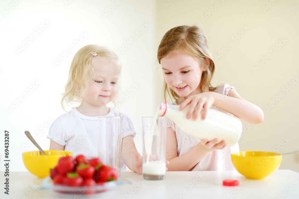 Two sisters eating cereal with milk Two sisters eating cereal with milk