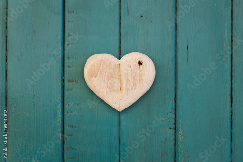 Love Valentines wooden heart on turquoise painted background