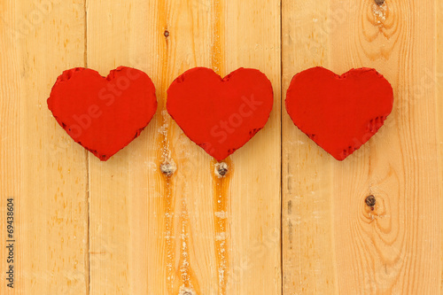 Love Valentines red cardboard hearts on rough pine background