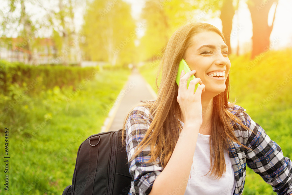 Teenage girl talking on the phone outdoors laughing Teenage girl talking on the phone outdoors laughing