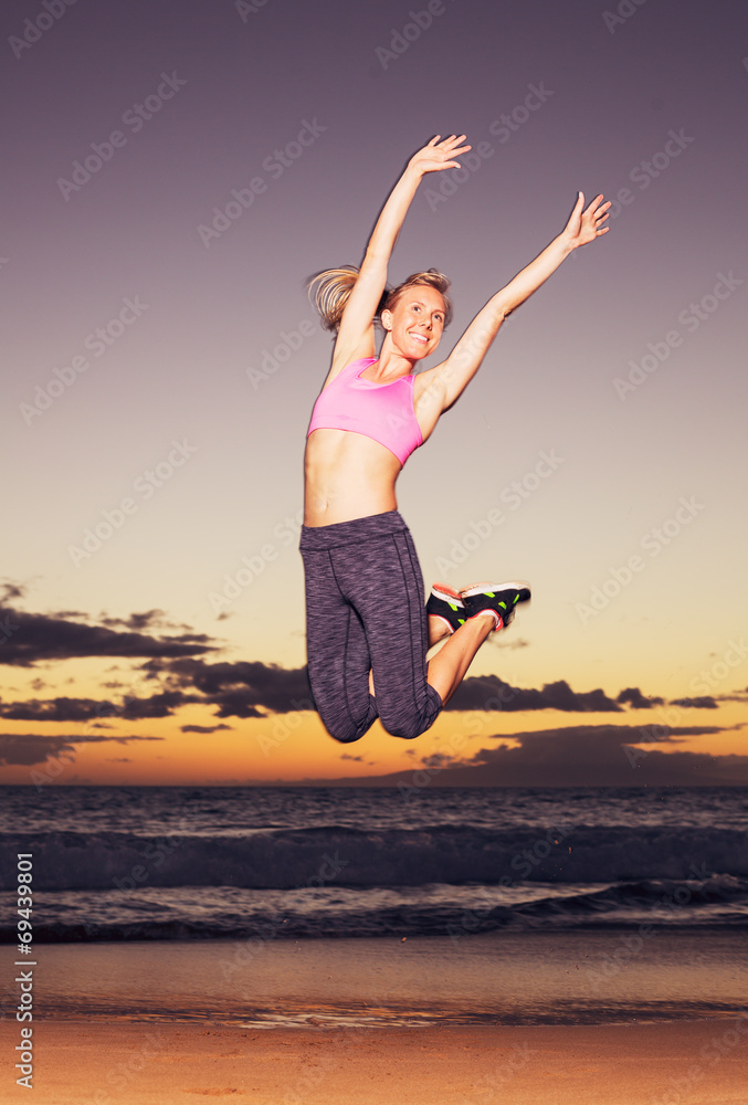 Woman jumping on the beach at sunset