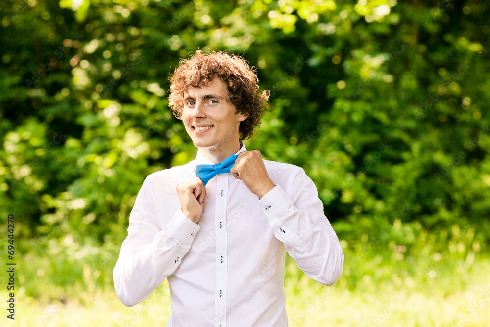 curly man in white shirt and blue bow tie smiling curly man in white shirt and blue bow tie smiling
