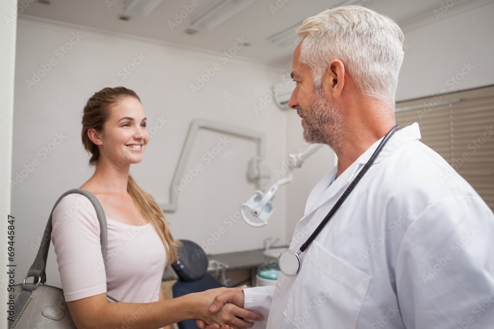 Dentist shaking hands with his patient Dentist shaking hands with his patient