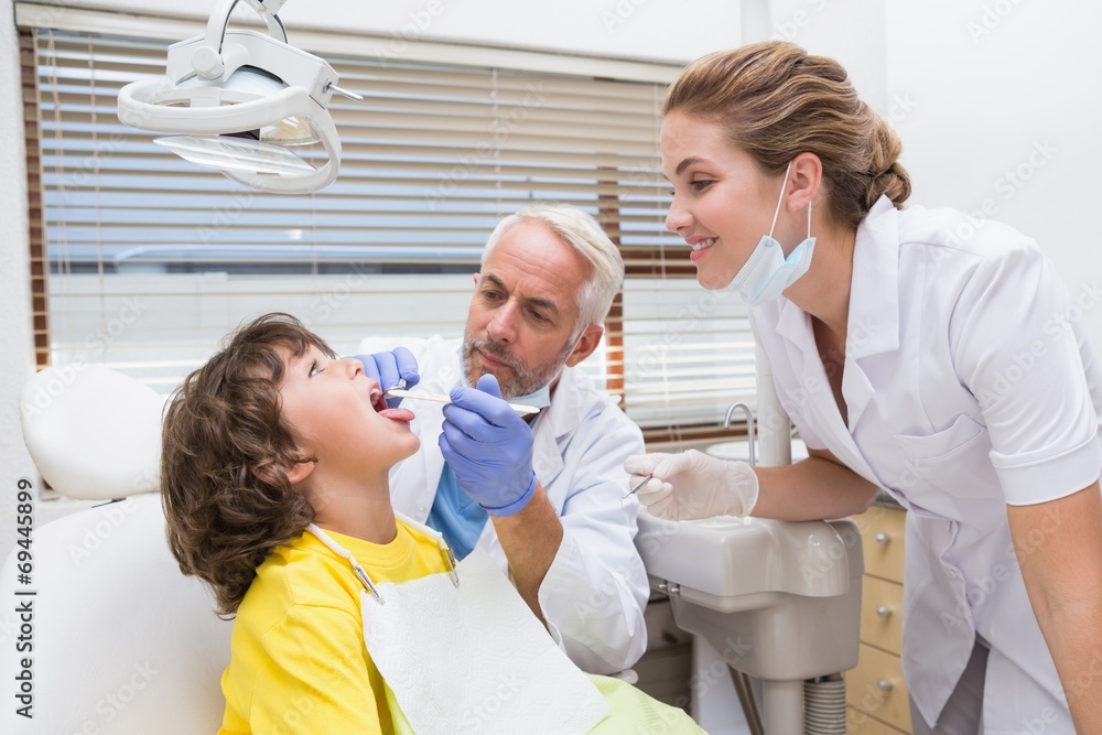 Pediatric dentist examining a little boys teeth Pediatric dentist examining a little boys teeth