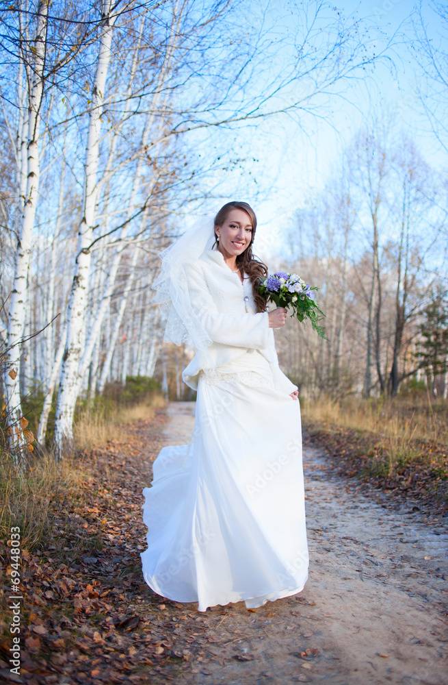 Young beautiful happy slim smiling bride girl woman on autumn wi