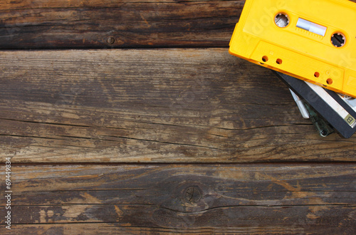 Cassette tapes over wooden table. top view.