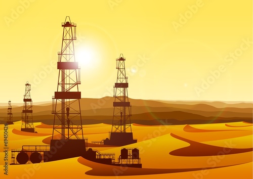 Landscape whith oil rigs in barren desert with sand dunes.