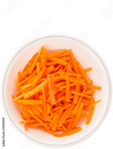 Chopped carrot in a bowl over white background