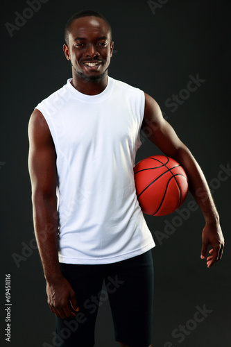Happy african american basketball player over black background